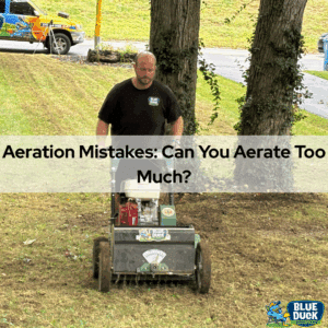 A Blue Duck Lawn Care technician aerates a residential lawn in Indiana using professional aeration equipment, with a Blue Duck service truck visible in the background.